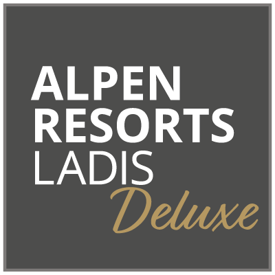 Square logo with a dark gray background. The text reads ALPEN RESORTS LADIS in white and Deluxe in gold cursive.