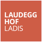 Red square with white text in bold that reads, LAUDEGG HOF LADIS.